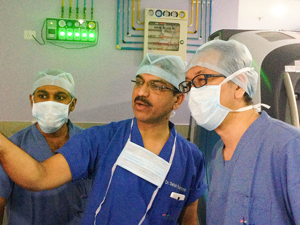 Doctors from both Sakra Wold Hospital and Japan discuss something in their blue scrubs.