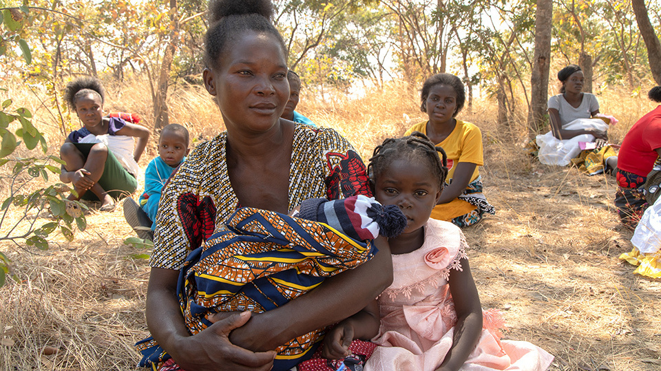 Women and children sitting outdoors.