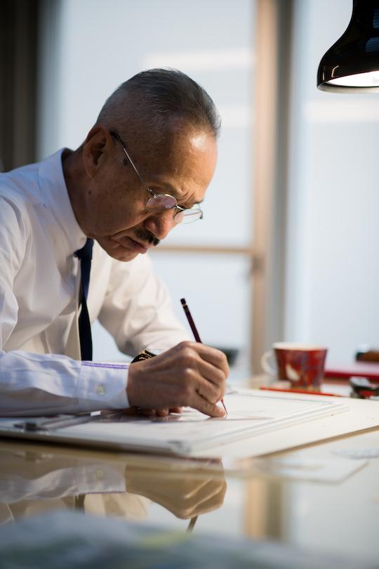 TAKAMATSU Shin is focusing on drawing his architectural idea at a desk.