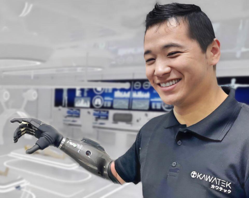 A man wearing a black shirt and a robotic arm.