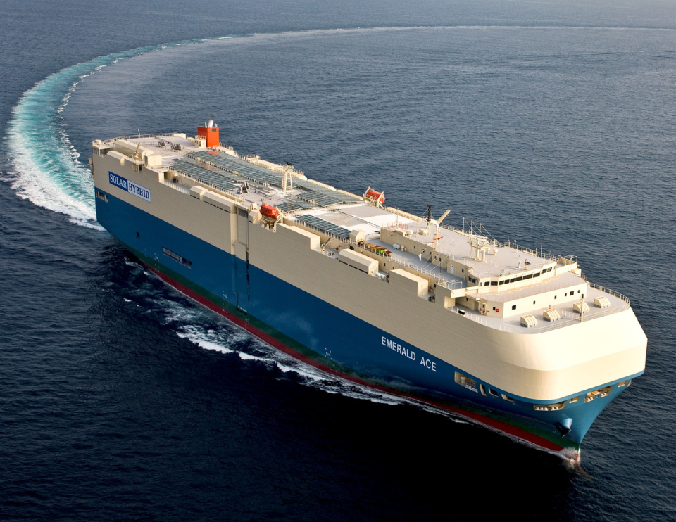 A large cargo ship sailing across the ocean on a sunny day