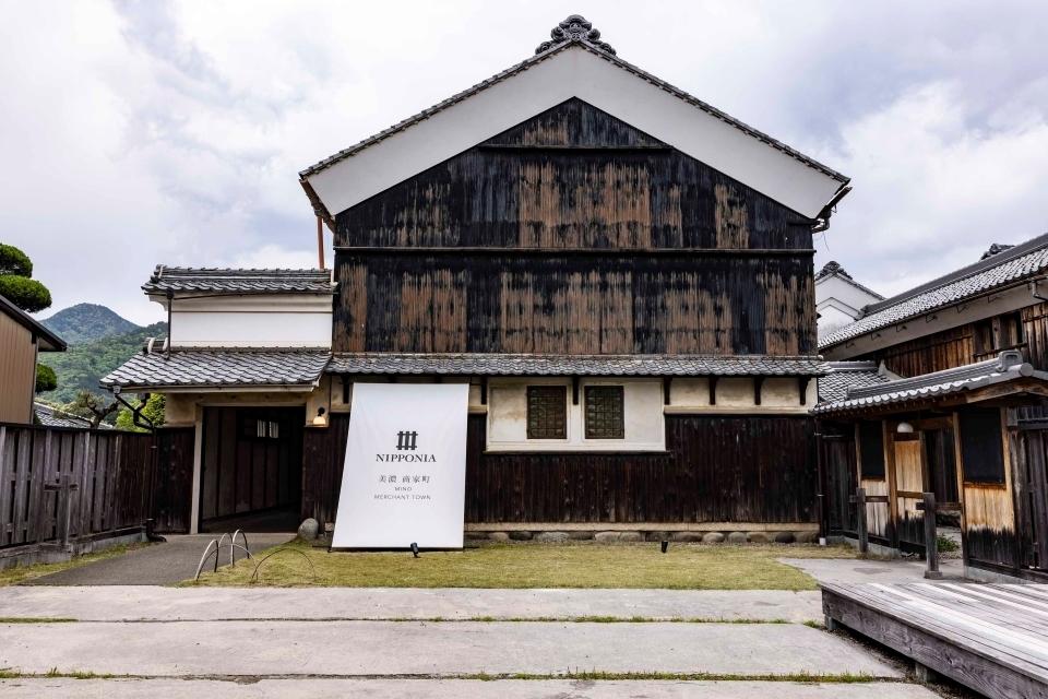 A traditional Japanese warehouse building built from dark wood that has been renovated into a hotel