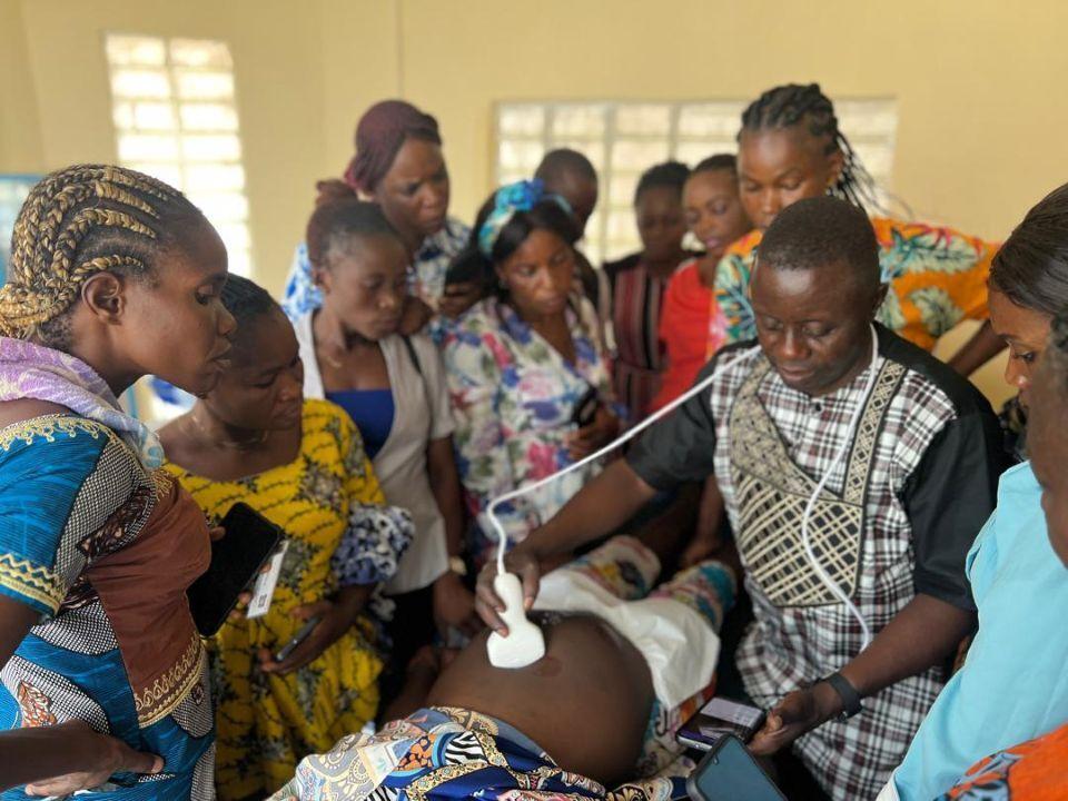A group of women learning how to use a portable sonograph