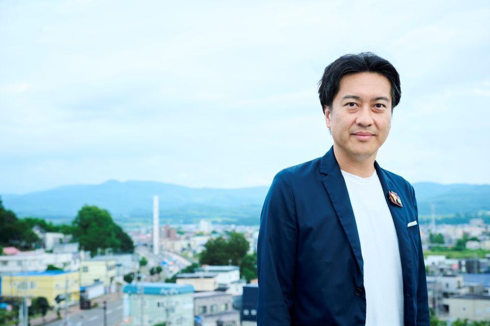 The mayor of Yoichi, in front of the townscape with mountains in the background